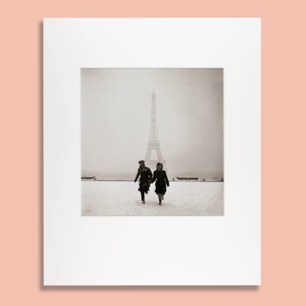 Photograph of couple running in front of the Eiffel Tower